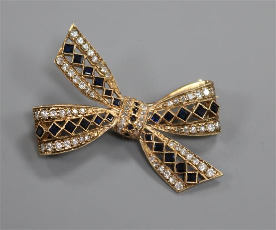 A modern 9ct gold, sapphire and diamond set ribbon bow brooch, 39mm.